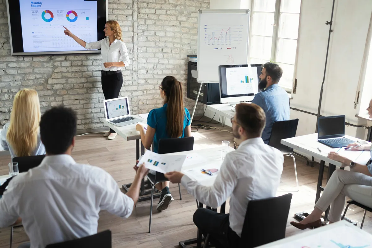 Profesionales siguiendo una presentación con diapositivas y gráficos